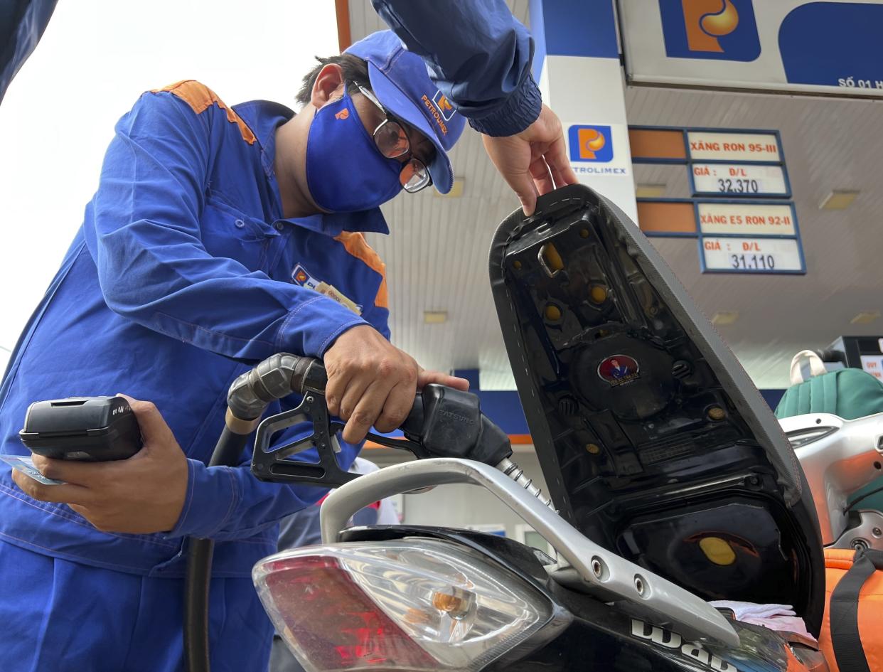 An attendant pumps gas into a motorcycle in Hanoi, Vietnam Sunday, June 19, 2022. Across the globe, drivers are rethinking their habits and personal finances amid skyrocketing prices for gasoline and diesel, fueled by Russia's war in Ukraine and the global rebound from the COVID-19 pandemic. Energy prices are a key driver of inflation that is rising worldwide and making the cost of living more expensive.(AP Photo/Hau Dinh)