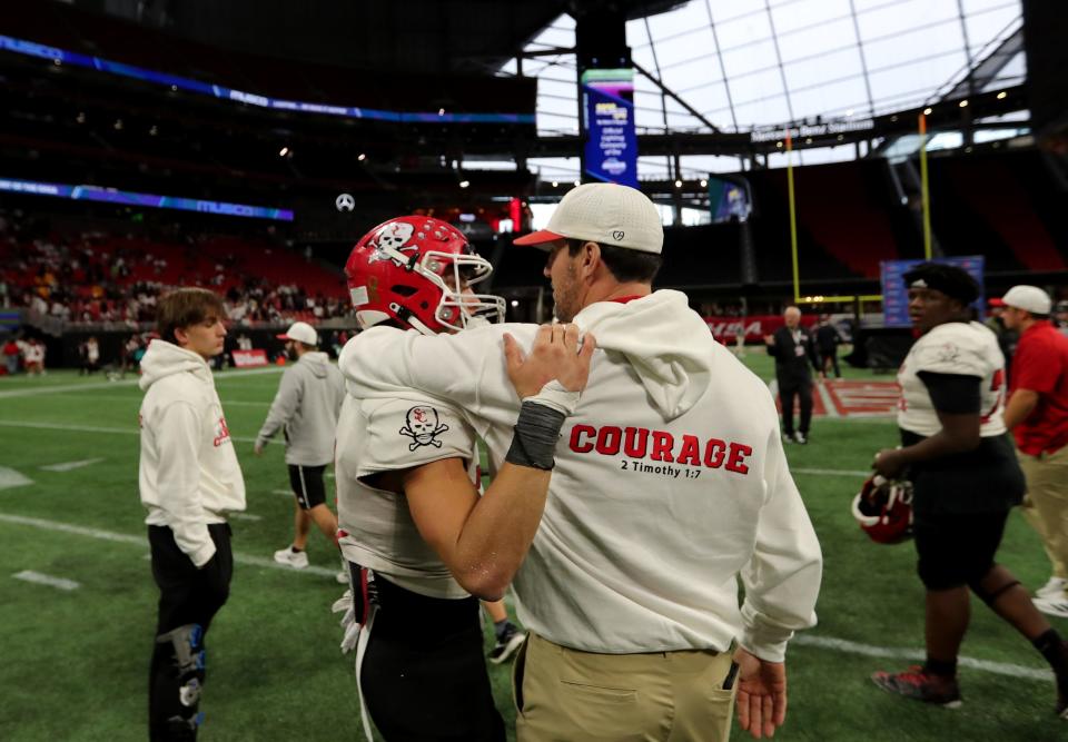 Savannah Christian coach Keith Brooking hugs David Bucey following the Raiders' 49-28 loss to Cedar Grove during the GHSA Class 3A State Championship game on Wednesday, December 13, 2023 at Mercedes-Benz Stadium in Atlanta, Georgia.