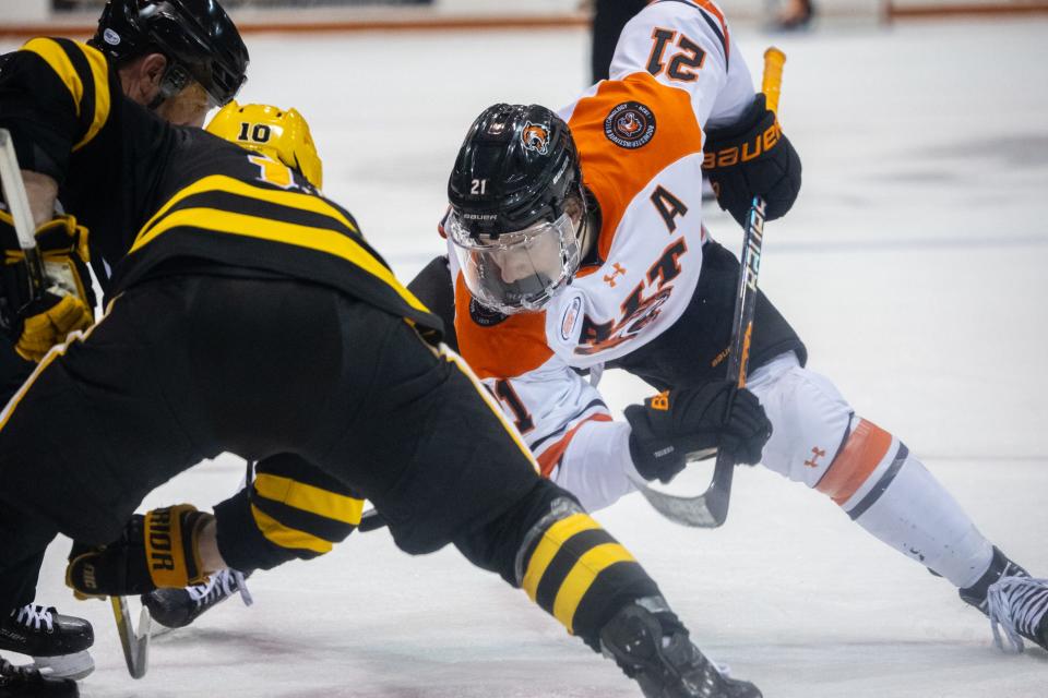 RIT's Carter Wilkie takes a face off against American International's Dustin Manz.