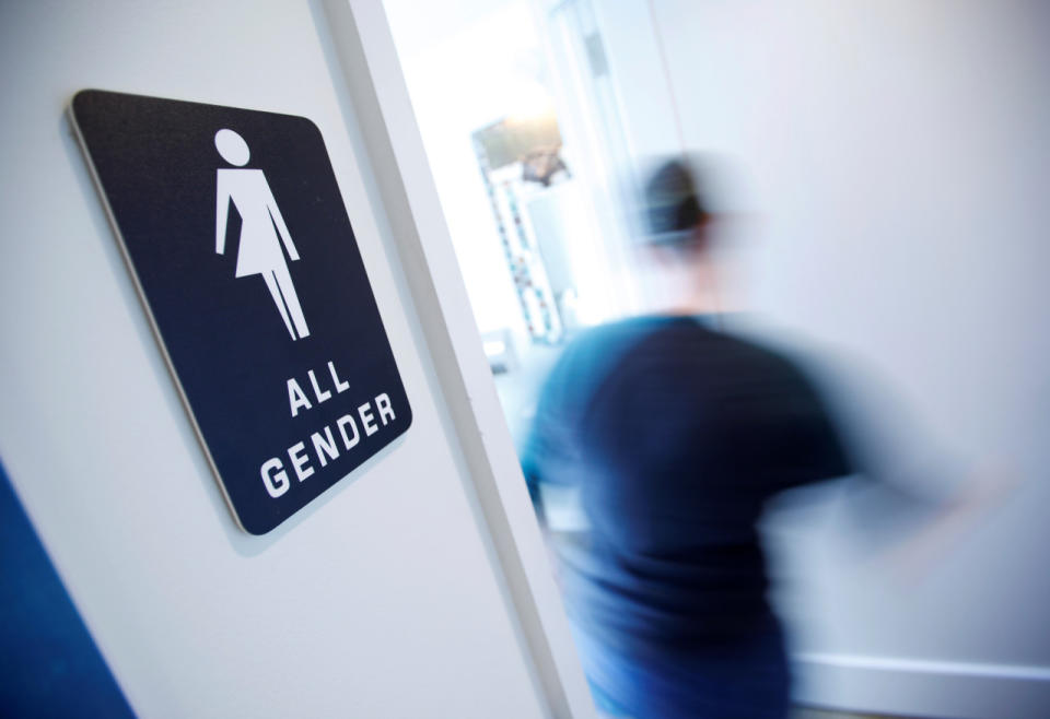 A bathroom sign welcomes both genders