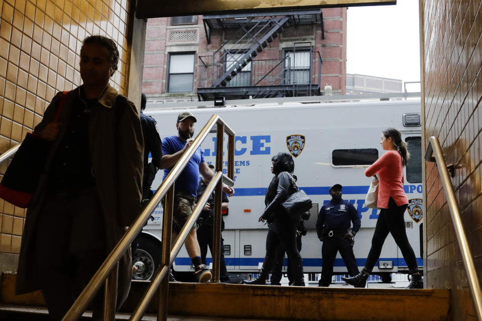 Pedestrians pass police officers at the Spring Street subway station before the Greenwich Village Halloween Parade, Thursday, Oct. 31, 2019, in New York. (AP Photo/Frank Franklin II)