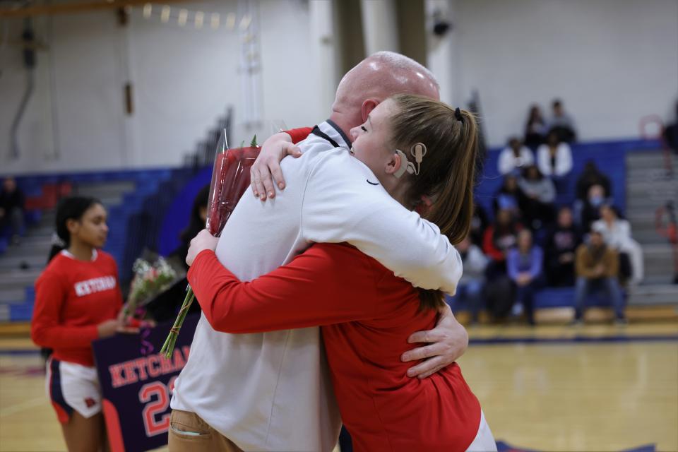 Ketcham's Camryn Greene shares a hug with girls basketball coach Pat Mealy during a senior night ceremony before their Feb. 7, 2023 game against Arlington.