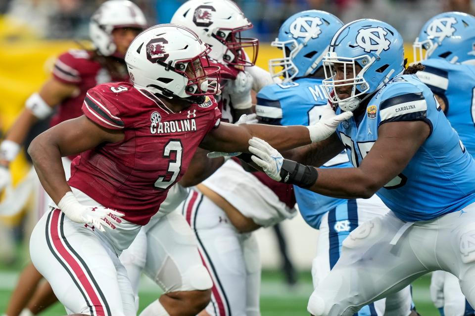 South Carolina Gamecocks defensive end Jordan Burch (3) tries to evade North Carolina Tar Heels offensive lineman Joshua Ezeudu (75) during the second quarter of the Duke's Mayo Bowl at Bank of America Stadium on Dec 30, 2021, in Charlotte. With Ezeudu and two other starting linemen declaring for the NFL Draft, UNC football is hitting the transfer portal to replace them.