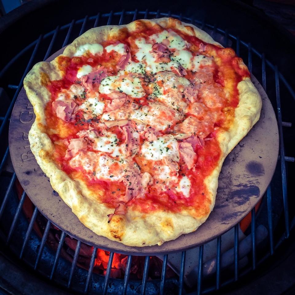 homemade pizza cooking on bbq grill