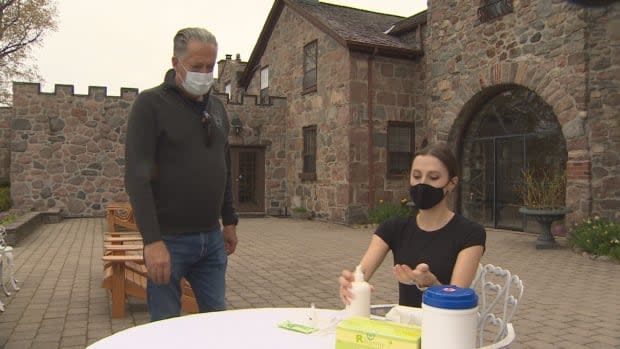 Jim Corcoran, owner of Ste. Anne's Spa in Grafton Ontario, looks on as an employee prepares to self-administer a rapid testing kit. He bought 3,000 kits after being told he wasn't eligible for ones from the province. (Doug Husby/CBC  - image credit)