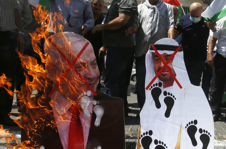 Palestinians burn pictures of Abu Dhabi Crown Prince Mohammed bin Zayed al-Nahyan and and Israeli Prime Minister Benjamin Netanyahu during a protest against the United Arab Emirates' deal with Israel, in the West Bank city of Nablus, Friday, Aug. 14, 2020.(AP Photo/Majdi Mohammed)