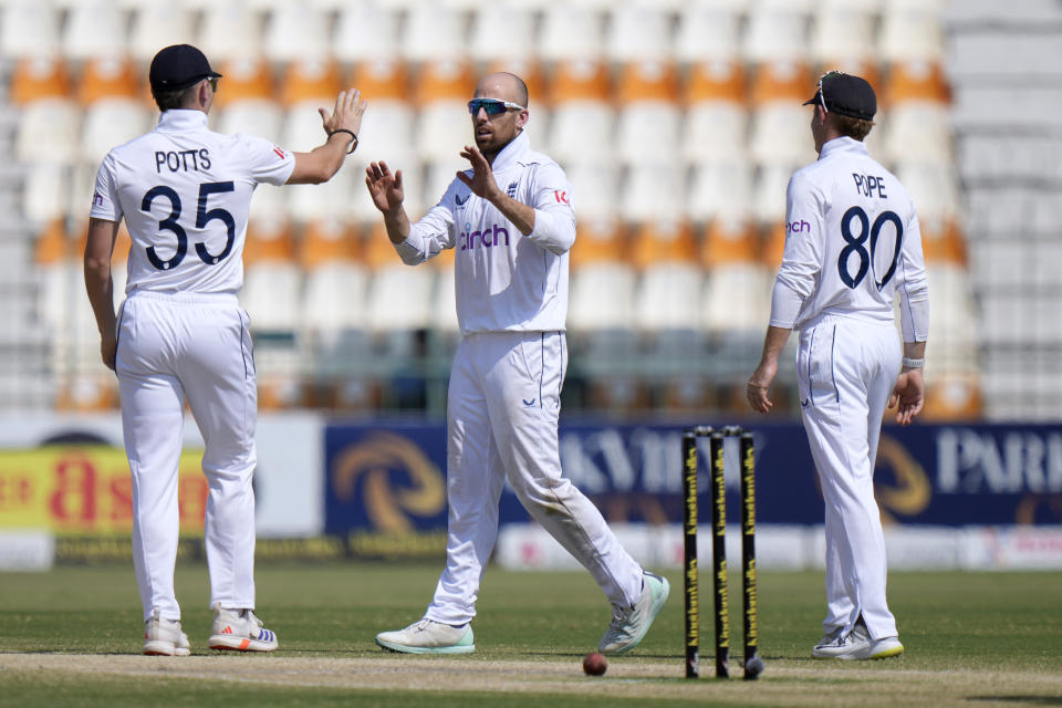 England's Jack Leach, center, celebrates with Ollie Pope after taking the wicket of Pakistan's Shaheen Shah Afridi during the fifth day of the first test cricket match between Pakistan and England, in Multan, Pakistan, Friday, Oct. 11, 2024. (AP Photo/Anjum Naveed)