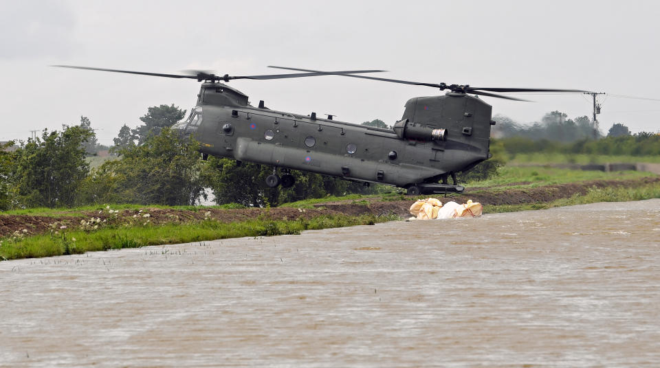 An RAF Chinook helicopter delivers personnel to the edge of the River Steeping (PA)