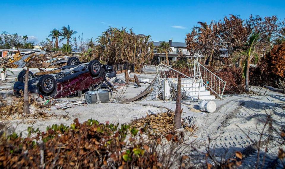 Un auto volcado y una escalera son algunos de los objetos esparcidos a lo largo de Estero Boulevard en Fort Myers Beach el miércoles, 26 de octubre de 2022. La zona fue gravemente dañada por el huracán Ian un mes antes.