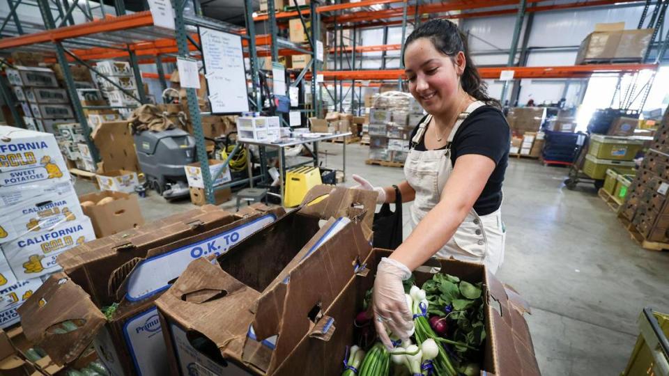 Natalie DeRose picks out vegetables at the SLO Food Bank, where volunteers and staff put together bags of produce on Dec. 5, 2023.