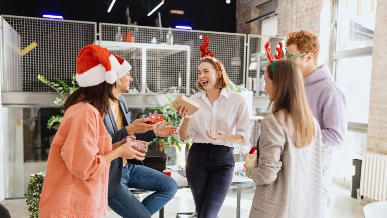 coworkers having secret santa exchange at the office