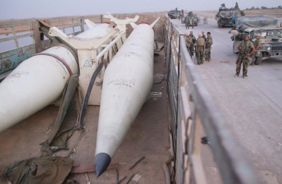 Two Iraqi Scud missiles in a trailor with soldiers in the background