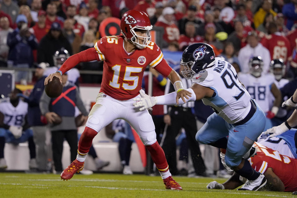 Kansas City Chiefs quarterback Patrick Mahomes scrambles under pressure from Tennessee Titans defensive end DeMarcus Walker (95) during the first half of an NFL football game Sunday, Nov. 6, 2022, in Kansas City, Mo. (AP Photo/Ed Zurga)
