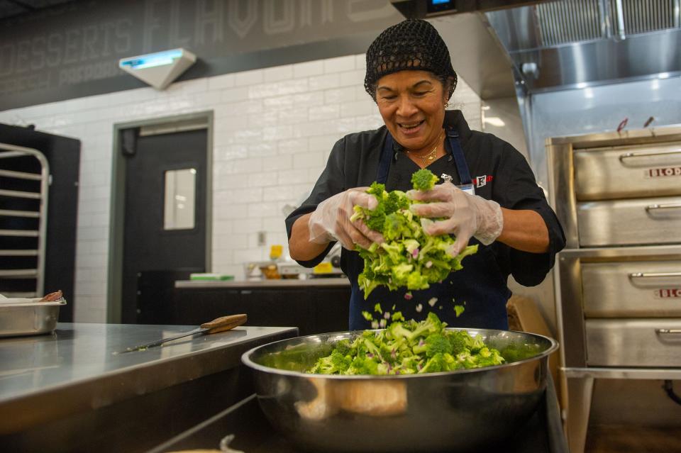 Deli worker Rosa Duran prepares broccoli salad at the Middlebrook Pike Food City.