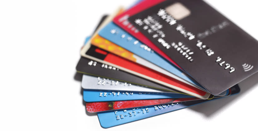 A stack of various credit cards fanned out on a white background