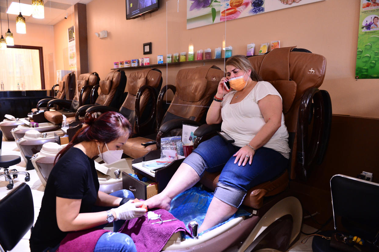 Nail technician Jimmie and her customer wear masks during a pedicure at Nails and Spa salon on May 20, 2020, in Miramar, Florida. (Photo: Johnny Louis via Getty Images)