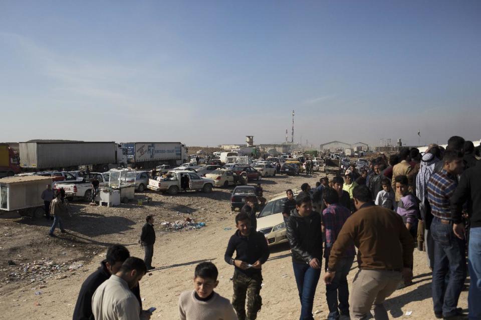 In this Tuesday Feb. 7, 2017 photo cars are lined up outside the Khazer checkpoint on the road from Irbil to Mosul. The United Nations says some 30,000 people have returned to neighborhoods in Mosul retaken from the Islamic State group since the operation to push the militants from the city was officially launched in October. (AP Photo/Bram Janssen)