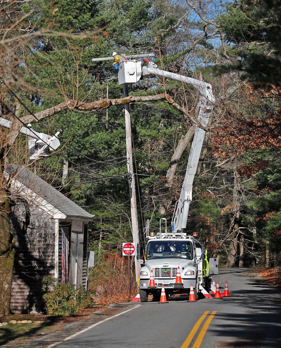 Utility workers try to restore power on School Street in Marshfield on Tuesday.