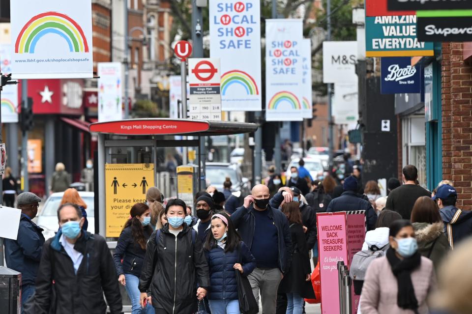 Pedestrians and shoppers, some wearing face masks as a precaution against the transmission of the novel coronavirus, walk in the high street in west London on October 11, 2020. - Prime Minister Boris Johnson is expected to outline the new regime on Monday as rates of Covid 19 infection surge particularly in the north, worsening a national death toll of more than 42,000 which is already the worst in Europe. (Photo by JUSTIN TALLIS / AFP) (Photo by JUSTIN TALLIS/AFP via Getty Images)