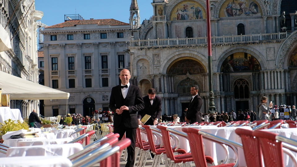 Waiters stand by an empty restaurant in St. Mark's Square, which would usually be full of tourists, as a coronavirus outbreak continues to grow in the country, in Venice, Italy, February 27, 2020. REUTERS/Manuel Silvestri