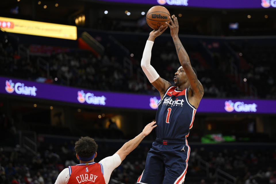 Washington Wizards guard Kentavious Caldwell-Pope (1) shoots against Philadelphia 76ers guard Seth Curry (31) during the first half of an NBA basketball game, Monday, Jan. 17, 2022, in Washington. (AP Photo/Nick Wass)