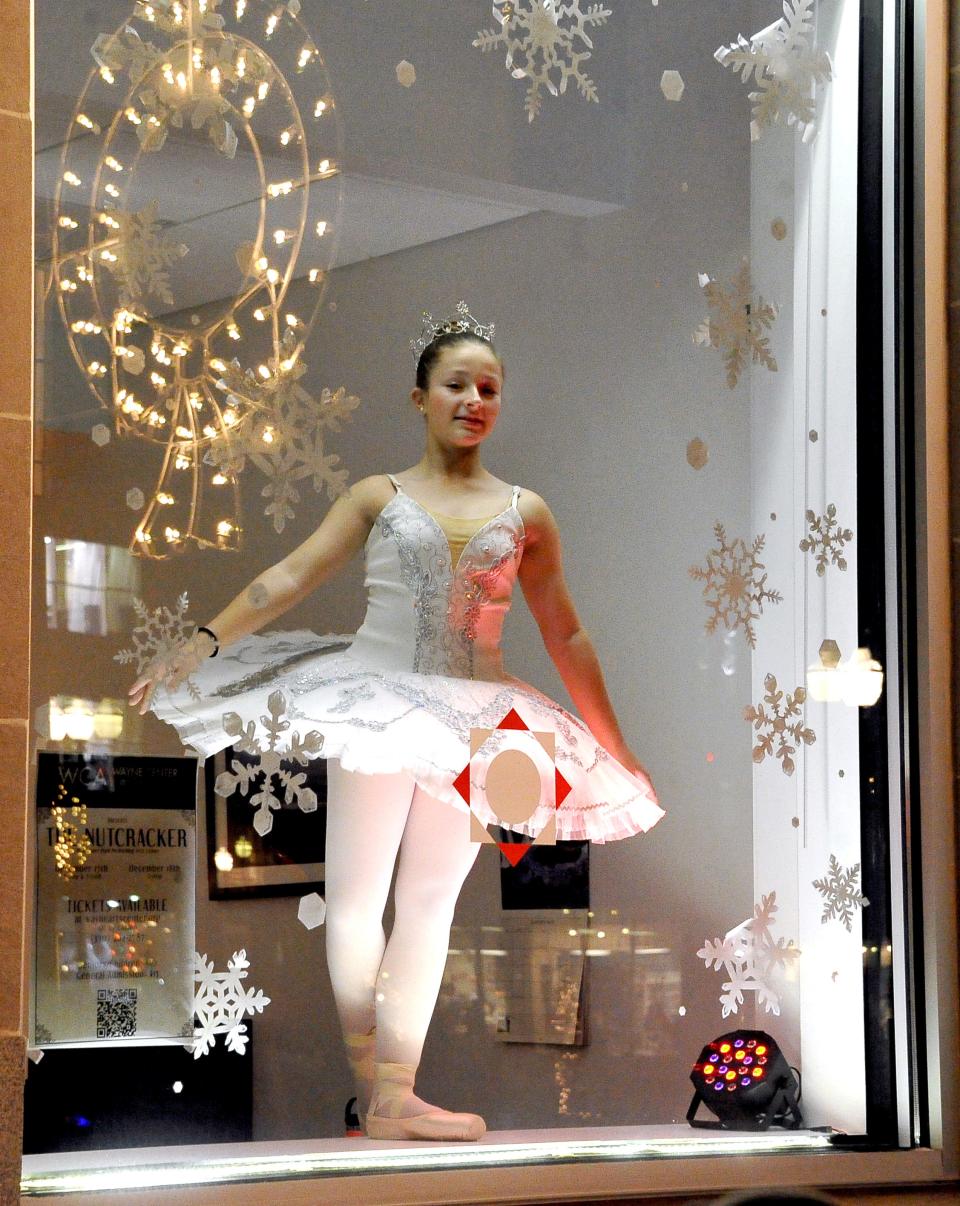 A motionless ballerina stands in a store window eyeing passersby. More than 4,000 people attended Main Street Wooster's annual holiday event that helps kick off the holiday shopping season.