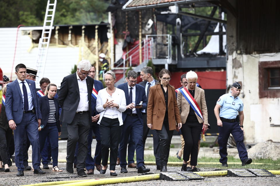French Prime Minister Elisabeth Borne speaks with officials as she visits the site where a fire erupted at a holiday home for disabled people in Wintzenheim, France, Wednesday, Aug. 9, 2023. Eleven people have died after a fire ripped through a vacation home for adults with disabilities in eastern France. The deputy prosecutor of Colmar said 11 people who were sleeping on the upper floor and in a mezzanine area of the private accommodation were trapped by the fire, while five managed to escape. (Sebastien Bozon, Pool Photo via AP)