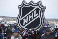 FILE - In this Saturday, Feb. 15, 2020, file photo, fans pose below the NHL league logo at a display outside Falcon Stadium before an NHL Stadium Series outdoor hockey game between the Los Angeles Kings and Colorado Avalanche, at Air Force Academy, Colo. The NHL Players’ Association’s executive board is voting on a 24-team playoff proposal as the return-to-play format, a person with knowledge of the situation told The Associated Press, late Thursday, May 21, 2020. (AP Photo/David Zalubowski, File)