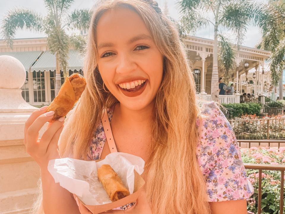 kayleigh price holding a cheeseburger egg roll at magic kingdom in disney world