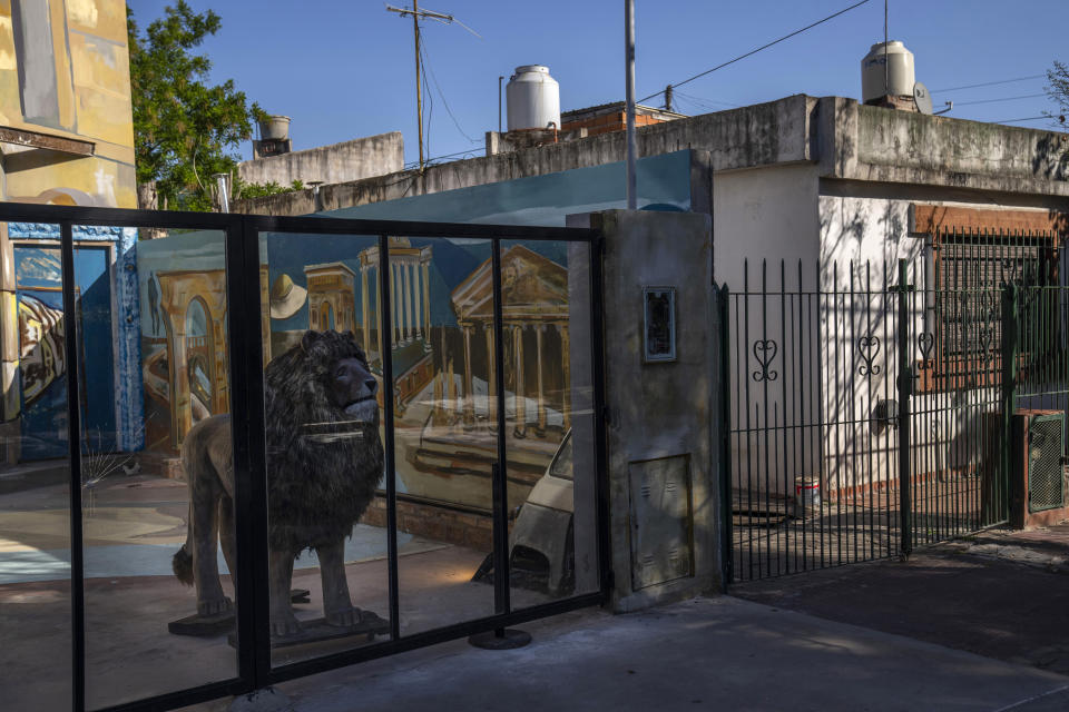 A wooden lion is set inside a replica of the Roman Colosseum that stands 26 feet high and covers over 2000 square feet, housing golden lion heads, gladiators, and a VIP area with an armchair for the emperor, in Ituzaingo, Argentina, Saturday, Oct. 29, 2022. It was created by the artist Rubén Díaz, who is considered a "generator of fantasies." He has several constructions around town inspired by European works. (AP Photo/Rodrigo Abd)