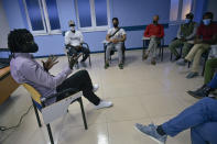 Mbaye Bbacar Diouf (izq) conversa con migrantes y voluntarios durante uno de los talleres que ofrece para ayudar a migrantes como él en Bilbao, España, el 18 de noviembre del 2020. (AP Photo/Álvaro Barrientos)