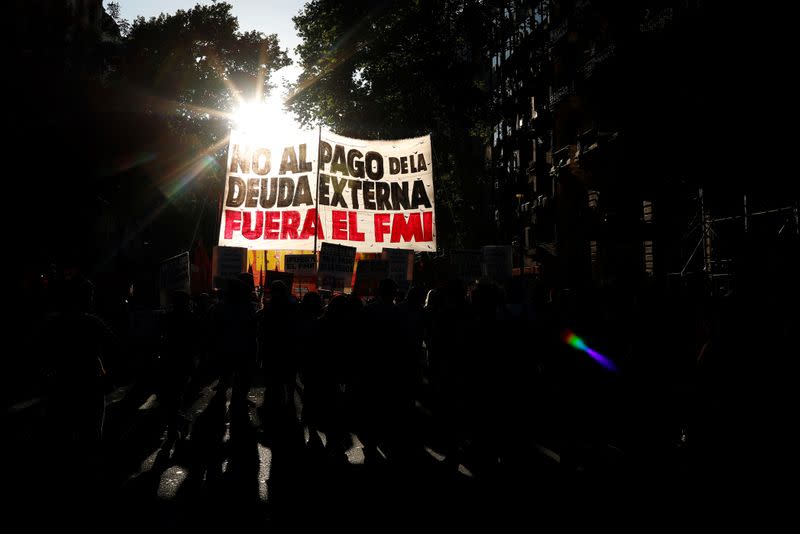 Manifestantes sostienen una pancarta mientras marchan hacia el palacio presidencial Casa Rosada durante una protesta contra la visita de un equipo técnico del FMI a Buenos Aires.