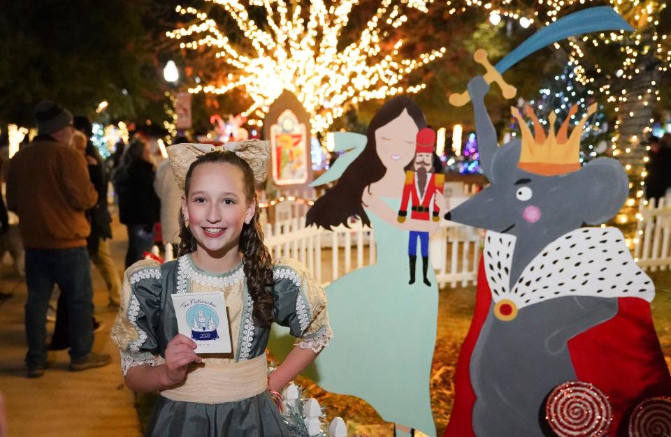 Rowan Bordner, a member of the Tuscaloosa Community Dancers, poses in front of the Nutcracker display during the opening night of the Tinsel Trail in Government Plaza in Tuscaloosa Monday, Nov. 27, 2023.