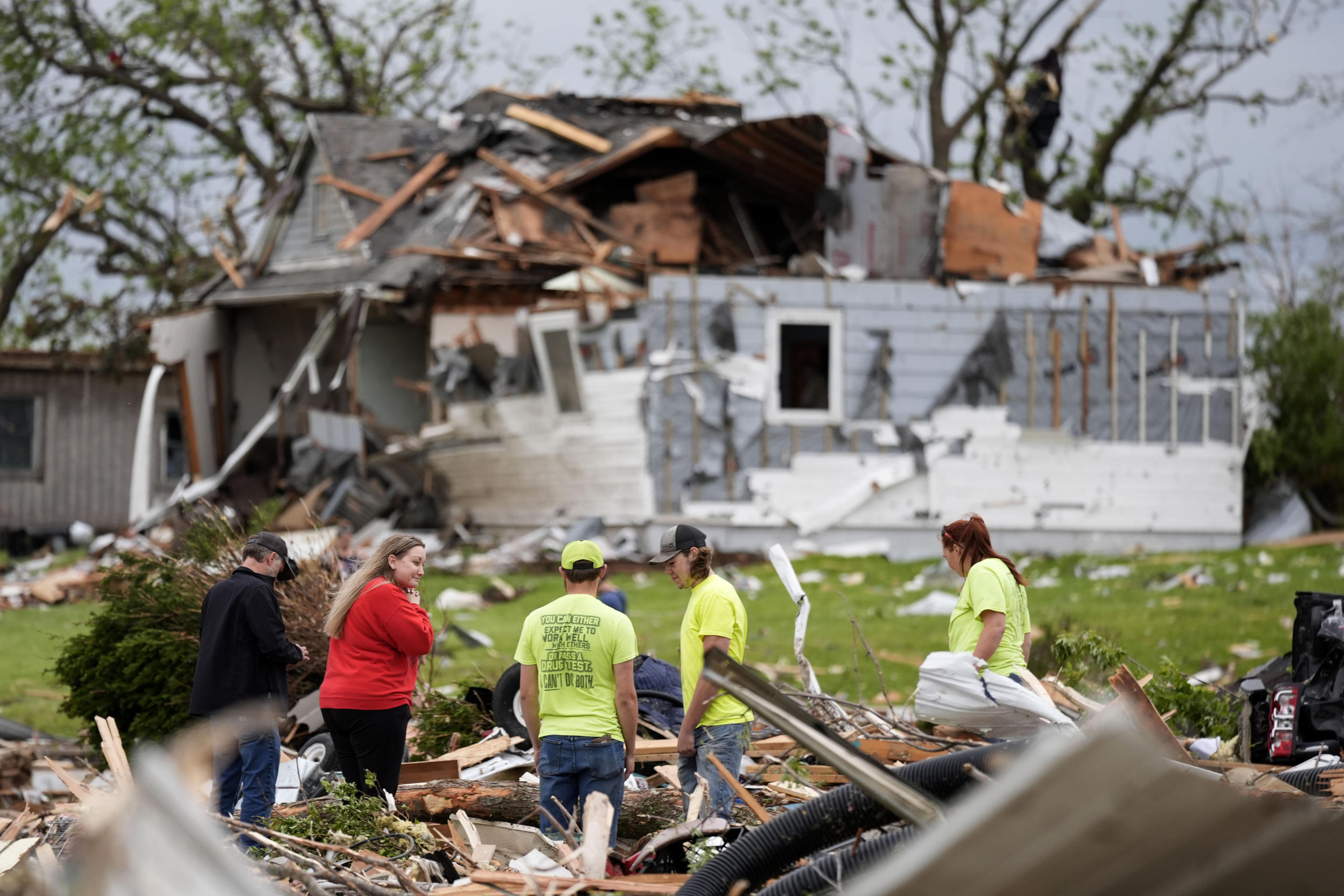 People sort through the remains of a home damaged by a tornado on Tuesday in Greenfield, Iowa.