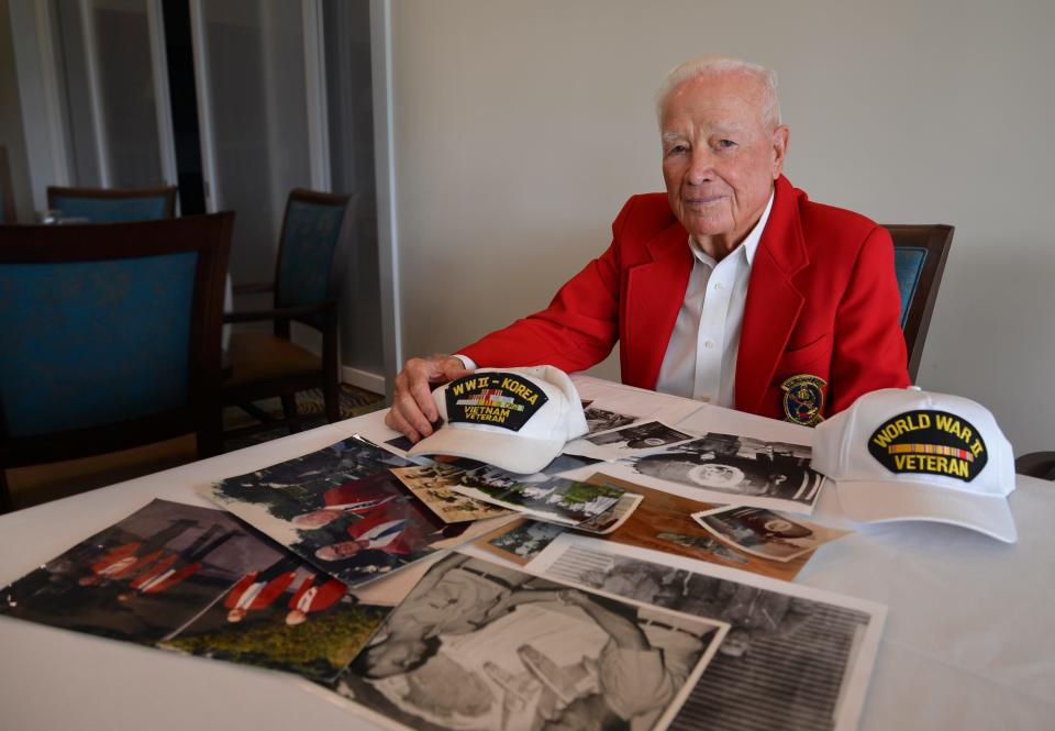 Don Mathews, a retired U.S. Air Force colonel who turned 96 on Saturday, smiles alongside his collection of military photographs at Suntree Country Club.