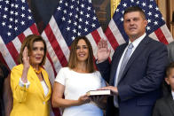 House Speaker Nancy Pelosi of Calif., left, poses during a ceremonial swearing-in for Rep. Brad Finstad, R-Minn., right, joined by his wife Jaclyn and their family, Friday, Aug. 12, 2022, on Capitol Hill in Washington. (AP Photo/Patrick Semansky)
