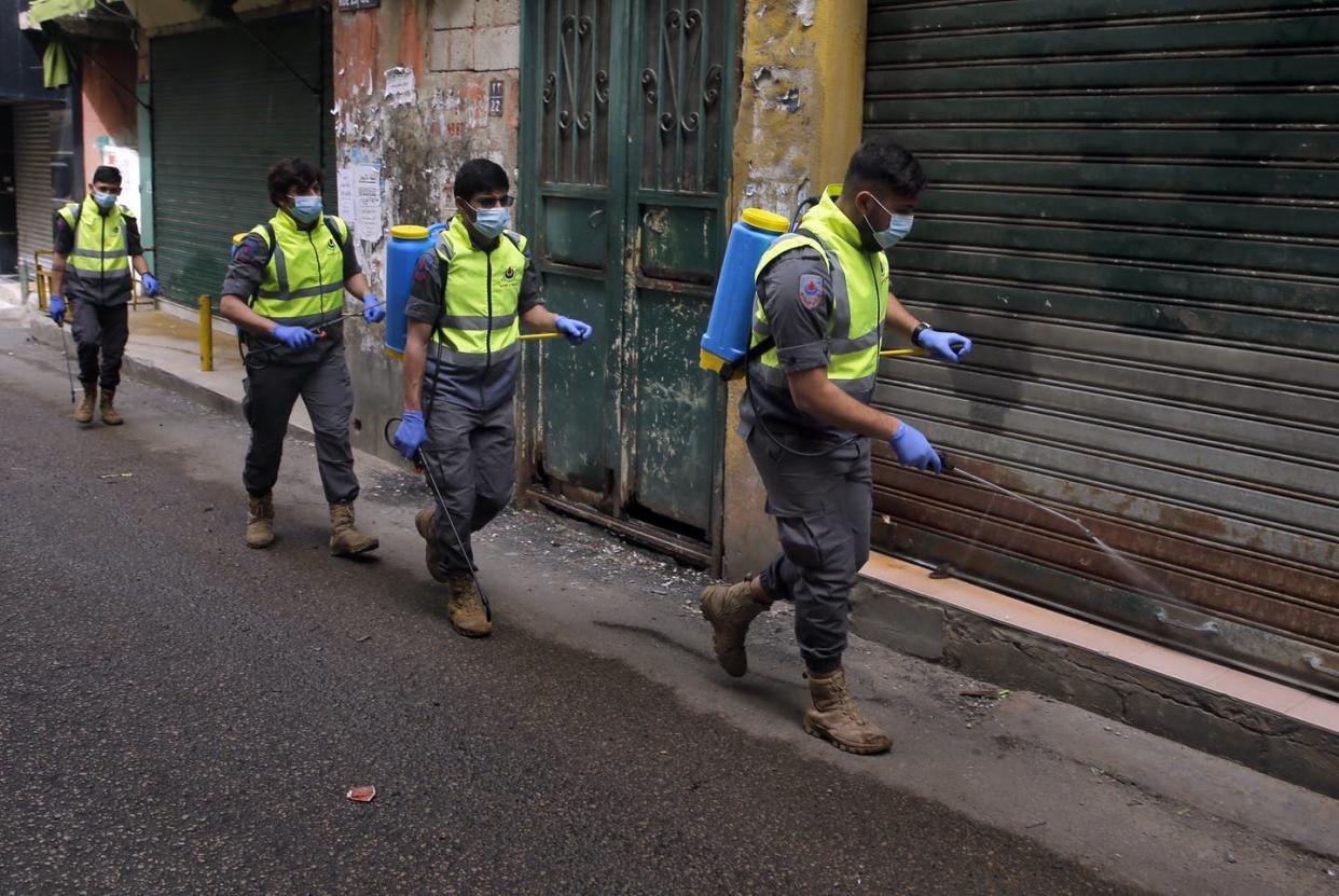 <span class="caption">Members of an arm of Hezbollah spray disinfectant in a Beirut neighborhood to fight the spread of the coronavirus.</span> <span class="attribution"><a class="link " href="http://www.apimages.com/metadata/Index/Virus-Outbreak-Hezbollah-New-Battle/1223e744fff7412084c3b1ad50e45580/3/0" rel="nofollow noopener" target="_blank" data-ylk="slk:AP Photo/Bilal Hussein;elm:context_link;itc:0;sec:content-canvas">AP Photo/Bilal Hussein</a></span>