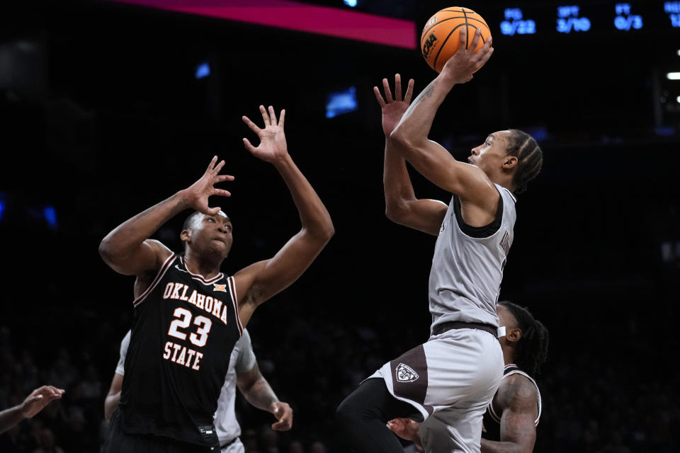 St. Bonaventure's Mika Adams-Woods, right, shoots over Oklahoma State's Brandon Garrison during the first half of an NCAA college basketball game in the Legends Classic tournament Thursday, Nov. 16, 2023, in New York. (AP Photo/Frank Franklin II)
