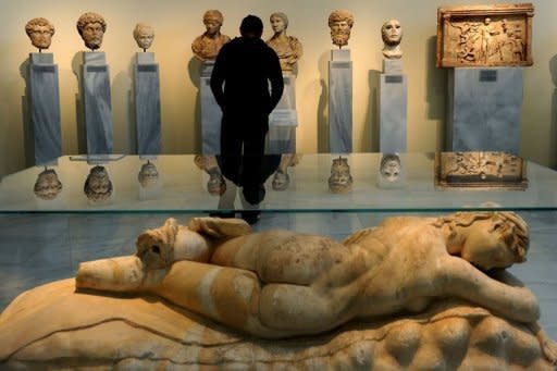 A visitor looks at antiquities at the National Archeological Museum in Athens on March 18, 2012. Faced with huge public debt as it moves into a fifth year of recession, Greece is finding that its fabled antiquity heritage is proving a growing burden. "Greece's historic remains have become our curse," whispered an archaeologist worried about budgets that are badly stretched to nonexistent