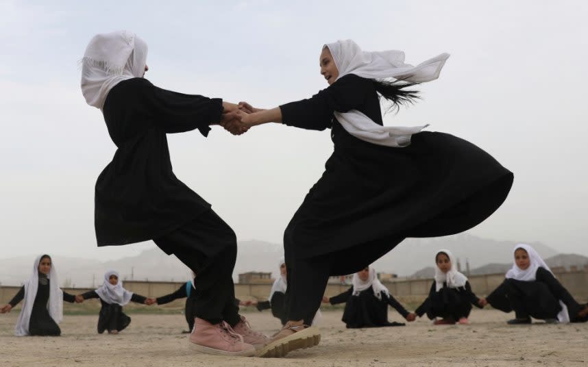 Afghan girls dance together during a game at a primary school in Kabul. CREDIT: AP - AP