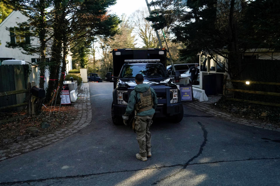 Secret Service personnel park vehicles in the driveway of President Biden's house.