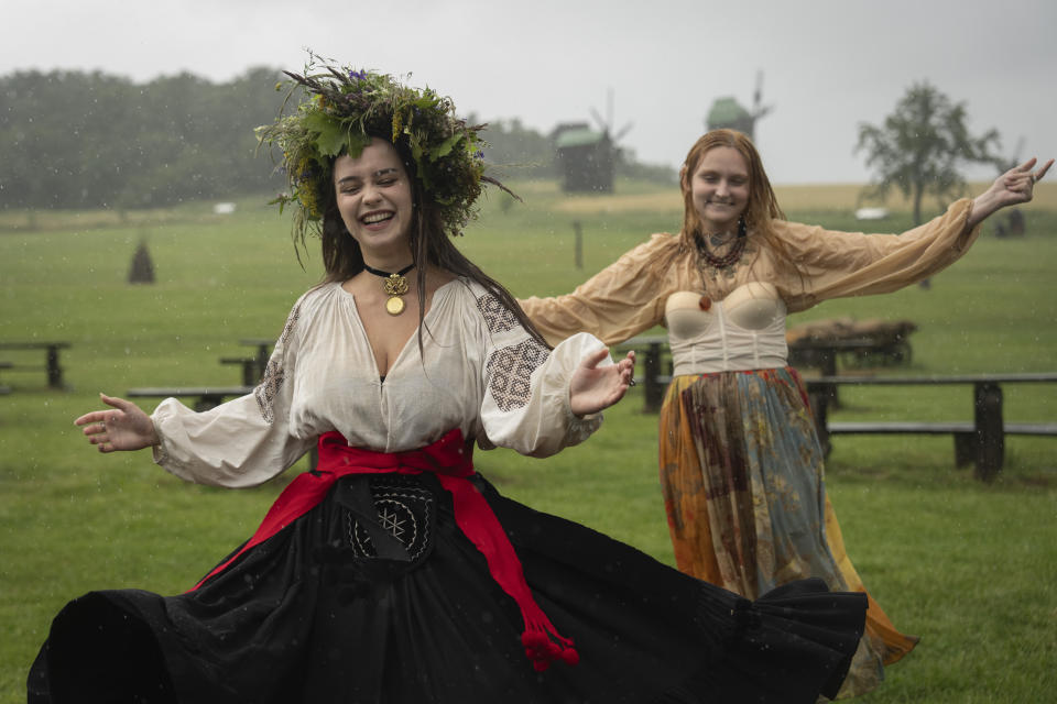 Ukrainian young women dressed in traditional clothing dance under heavy rain at a traditional Midsummer Night celebration near capital Kyiv, Ukraine, Sunday, June 23, 2024. The age-old pagan festival is still celebrated in Ukraine amid the third year of Russia-Ukraine war. (AP Photo/Efrem Lukatsky)