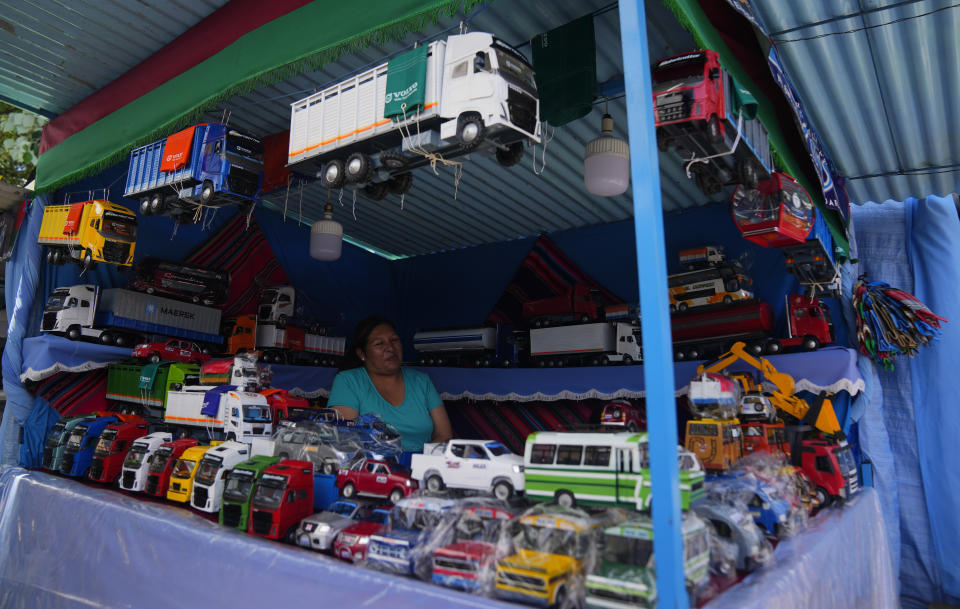 Un vendedor de vehículos en miniatura espera clientes durante la feria anual de Alasita en el centro de La Paz, Bolivia, el miércoles 24 de enero de 2024. En el día de inauguración de la feria se ofrecen réplicas en miniatura de las cosas que las personas anhelan o desean, como casas, vehículos o salud, para que se conviertan en realidad. Alasita es una palabra aymara que significa "cómprame". (AP Foto/Juan Karita)