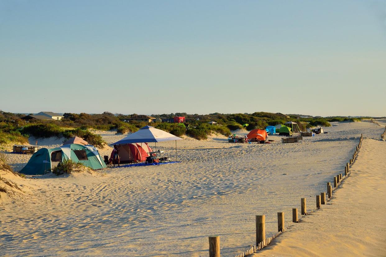 A tent camping area in the sand dunes at the Assateague Island National Seashore on a cloudless August morning with the tourist still asleep in their tents