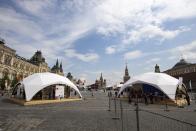 Outdoor book markets under tents are set up at Red Square with GUM, left, St. Basil's Cathedral, center, Spasskaya Tower, second with, and the Kremlin Wall, right, in Moscow, Russia, Saturday, June 6, 2020. Muscovites clad in face masks and gloves ventured into Red Square for an outdoor book market, a small sign of the Russian capital's gradual efforts to open up amid coronavirus concerns. (AP Photo/Alexander Zemlianichenko)