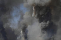 A helicopter of the Greek Fire Service flies during a wildfire that broke out in Tatoi, northern Athens, Greece, Tuesday, Aug. 3, 2021. The Greek Fire Service maintained an alert for most of the country Tuesday and Wednesday, while public and some private services shifted operating hours to allow for afternoon closures. (AP Photo/Michael Varaklas)