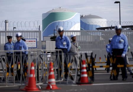 Security personnel stands guard in front of an entrance gate of Kyushu Electric Power's Sendai nuclear power station in Satsumasendai, Kagoshima prefecture, Japan, August 7, 2015. REUTERS/Issei Kato