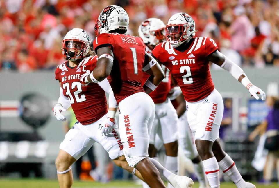 N.C. State linebacker Drake Thomas (32), Isaiah Moore (1) and Jaylon Scott (2) celebrate a stop during the first half of N.C. State’s game against Furman at Carter-Finley Stadium in Raleigh, N.C., Saturday, Sept 18, 2021.