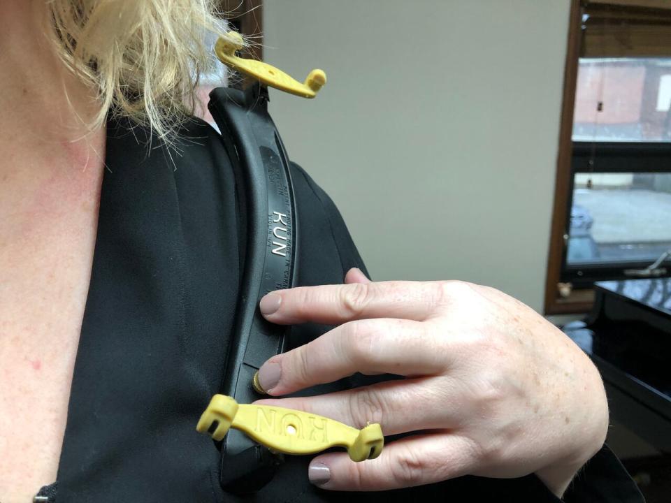 One of Eric Trachy's victims holds a violin shoulder rest. (Amy Dodge/CBC - image credit)