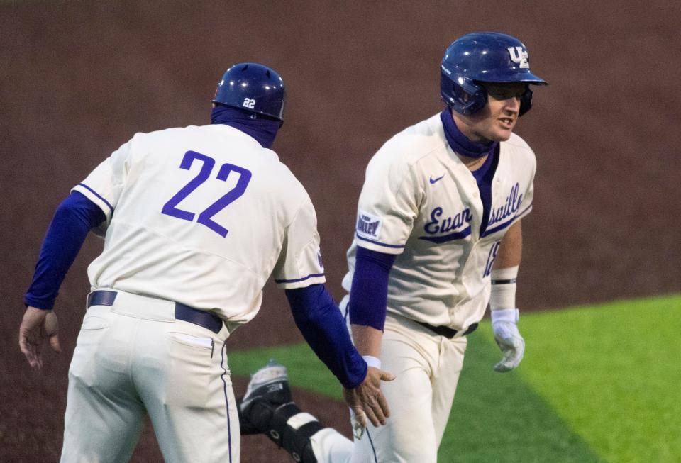 Evansville Head Coach Wess Carroll congratulates  Evansville’s Tanner Craig (18) as he rounds third after hitting a home run as the University of Evansville Purple Aces play the Missouri State Bears at German American Bank Field at Charles H. Braun Stadium in Evansville, Ind., Friday evening, April 16, 2021. 